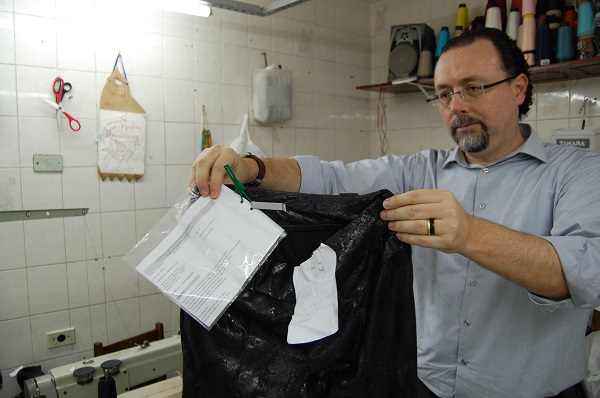 Deputado Carlos Bezerra Jr., presidente da CPI do Trabalho Escravo, segura calça da M. Officer encontrada oficina