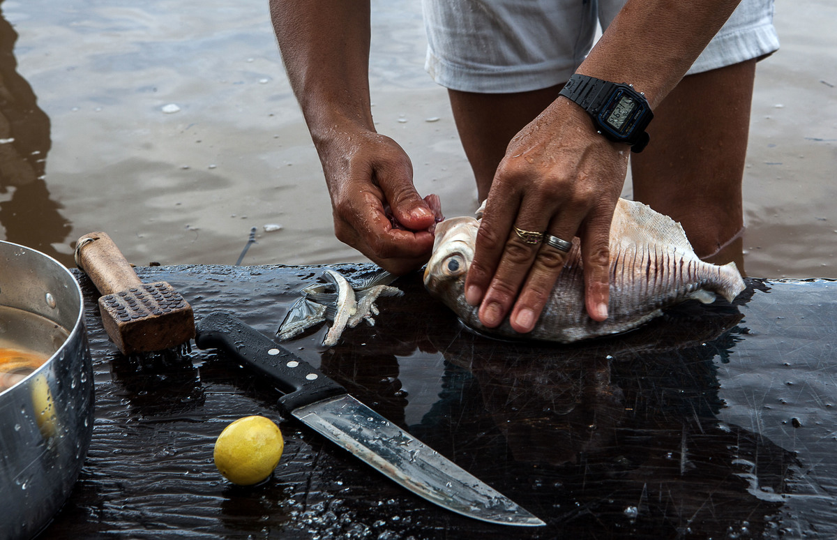 Mulher limpa o pescado no próprio Tapajós antes de levar o peixe para casa. Foto: Lilo Clareto/Reporter Brasil