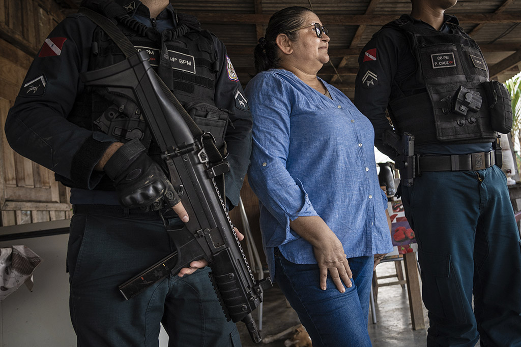 Marabá, Pará, Brasil 27-09-2023 Retrato da sindicalista ameaçada de morte Maria Joel Dias da Costa (camisa azul) durante visita a pequenos produtores rurais, sempre escoltada por dupla de policiais militares em assentamento próximo de Rondon do Pará.  Série de reportagens do projeto Pulitzer Center sobre violência no campo. Percorremos assentamentos e acampamentos em várias cidades do Mato Grosso e Pará, mostrando como a política do governo do ex–presidente Jair Bolsonaro amplificou a violência na Amazônia. ©Foto: Fernando Martinho