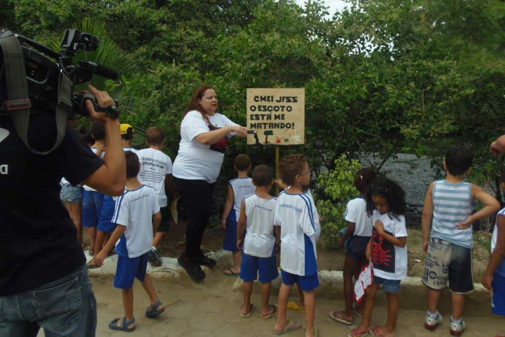 Professora Fabíola e seus alunos de cinco anos afixaram placas com mensagens de conscientização na beira do rio (Foto: Arquivo pessoal)