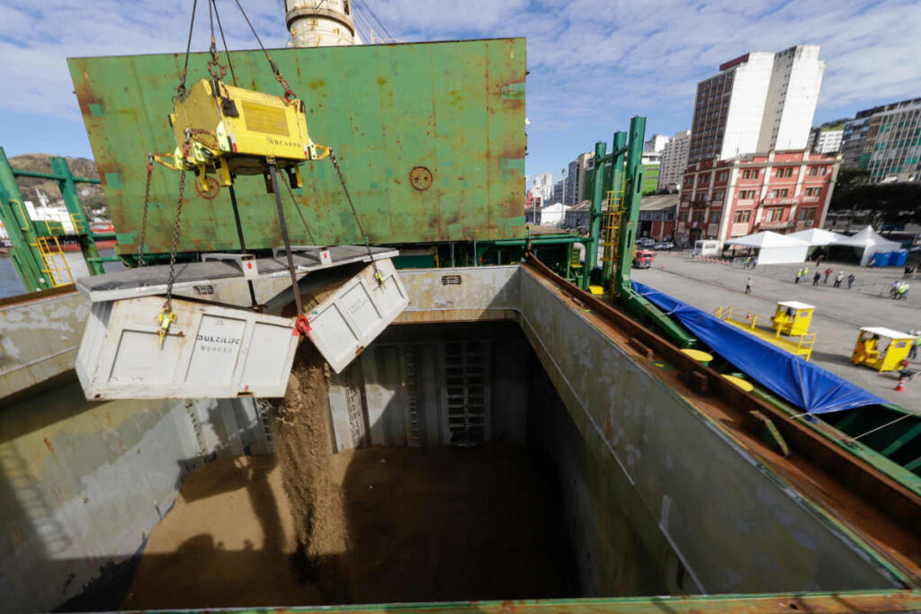 Imagem mostra embarque das primeiras 15 mil toneladas de lítio "quíntuplo zero" da mineradora Sigma Lithium, em julho de 2023, no porto de Vitória (ES). Produto fo extraído e processado no vale do Jequitinhonha, norte de Minas Gerais (Foto: Cristiano Machado/Imprensa MG)