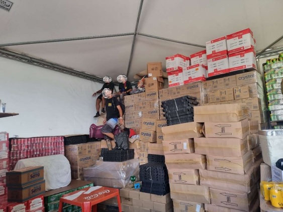 Trabalhadores retiram pertences pessoais escondidos atrás de caixas, dentro da tenda plástica fornecida pela como alojamento pela empresa Ozone, contratada pela organizadora do Lollapalooza (Foto: Reprodução/MTE)
