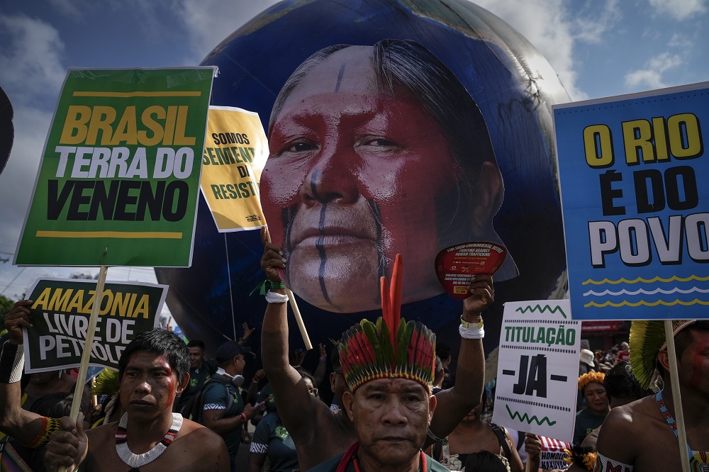 Kayapós carregam cartazes e foto da guerreira Tuíre Kayapó, durante a Marcha Mundial pelo Clima, em Belém, na COP30 (Foto: Fernando Martinho/Repórter Brasil)