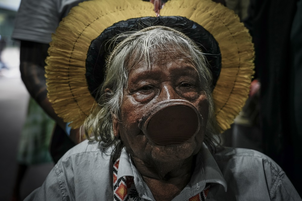 Retrato do cacique Raoni Metuktire, uma das principais lideranças indígenas do Brasil, chegando de cadeira de rodas para negociar com o presidente da COP30, André Corrêa do Lago, na Blue Zone (Foto: Fernando Martinho/Repórter Brasil)