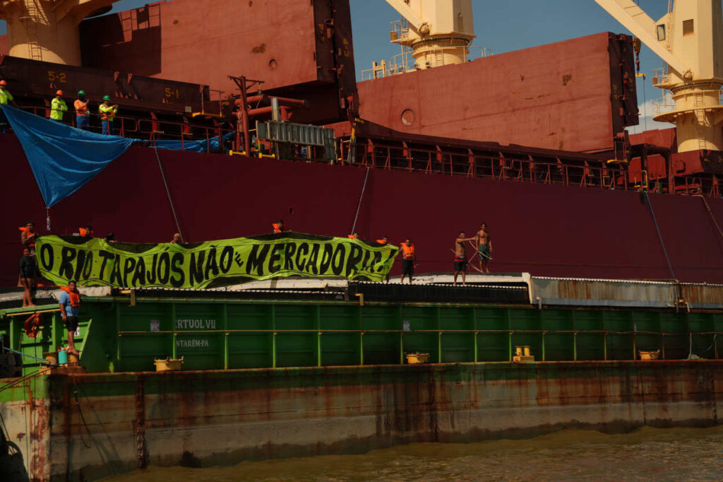Armados com arcos e flechas, indígenas sobem em uma balsa atracada no porto da Cargill, em Santarém (Foto: Coletivo Apoena Audiovisual)